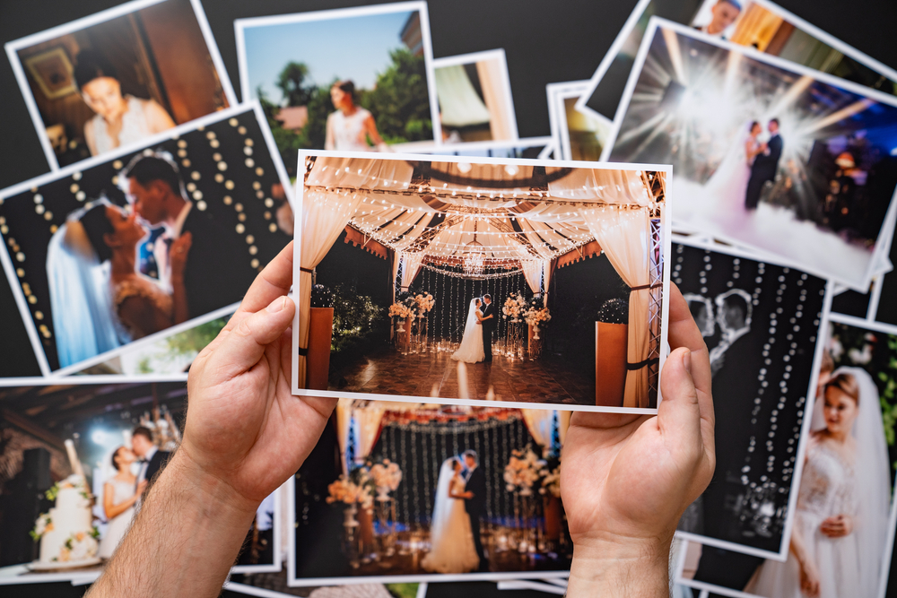 Hands,Lay,Out,A,Printed,Copy,Of,The,Wedding,Photos.